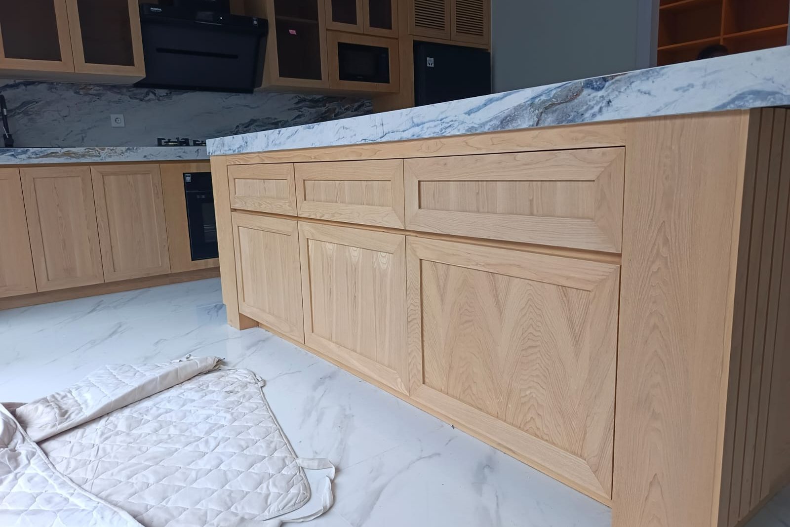 Timber joinery being installed beneath a marble worktop